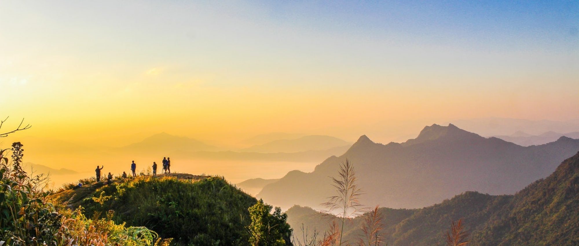 photo-of-people-standing-on-top-of-mountain-near-grasses-733162.jpg